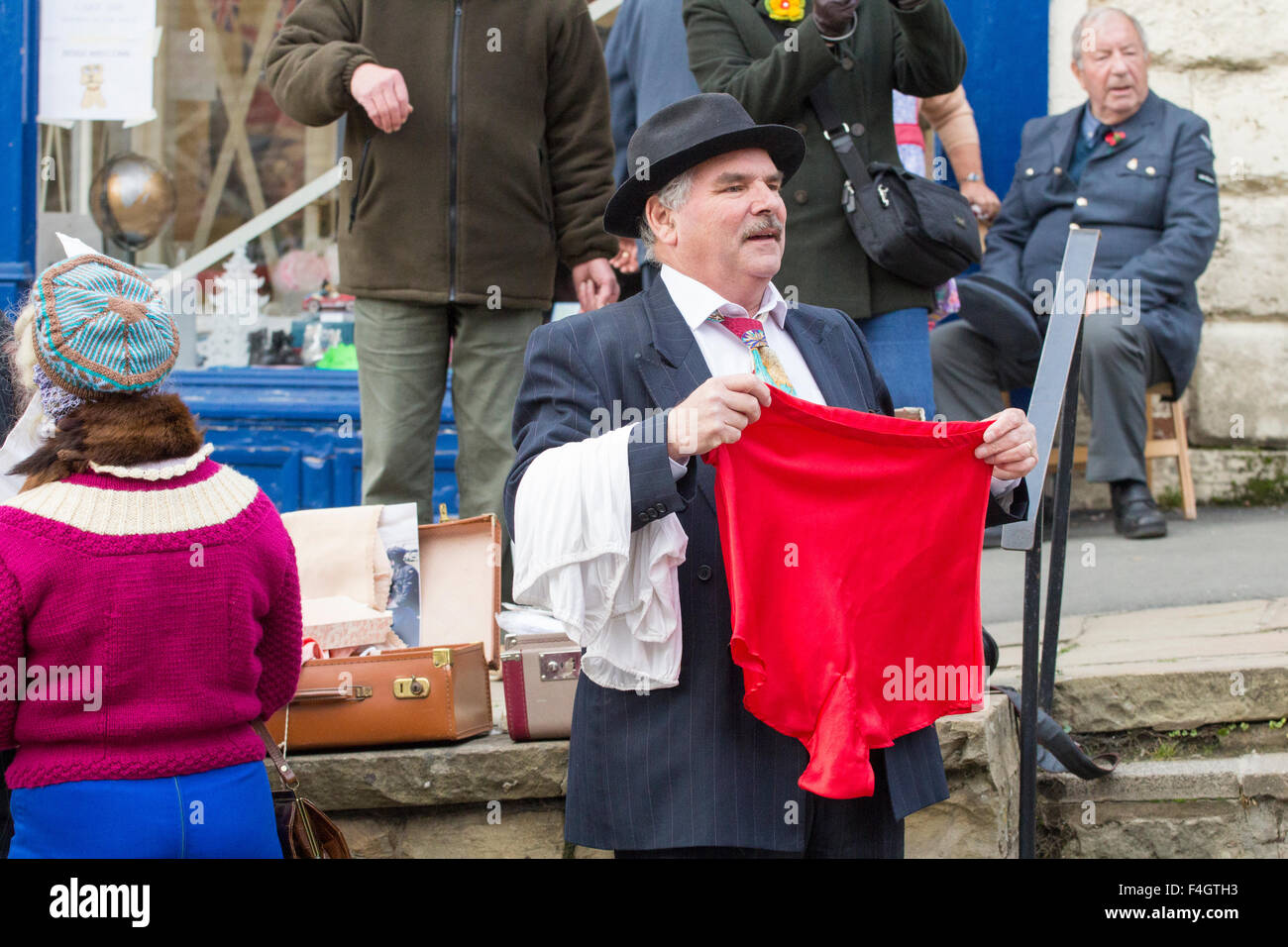 Pickering, North Yorkshire, UK. 17th October, 2015. Pickering`s annual Wartime and 40`s Weekend attracts thousands, with World War 2 living history camps and battle re-enactments amomg the attractions. PICTURED:  Man pretending to sell silk knickers and stockings. Stock Photo